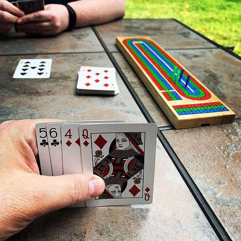 2 people playing cribbage on picnic table