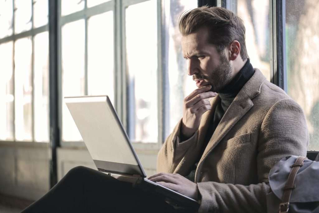 man looking confused, looking at laptop