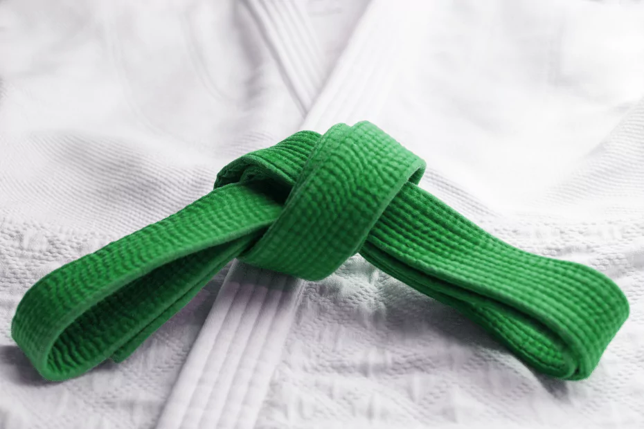 white karate robe, green belt folded on top. 