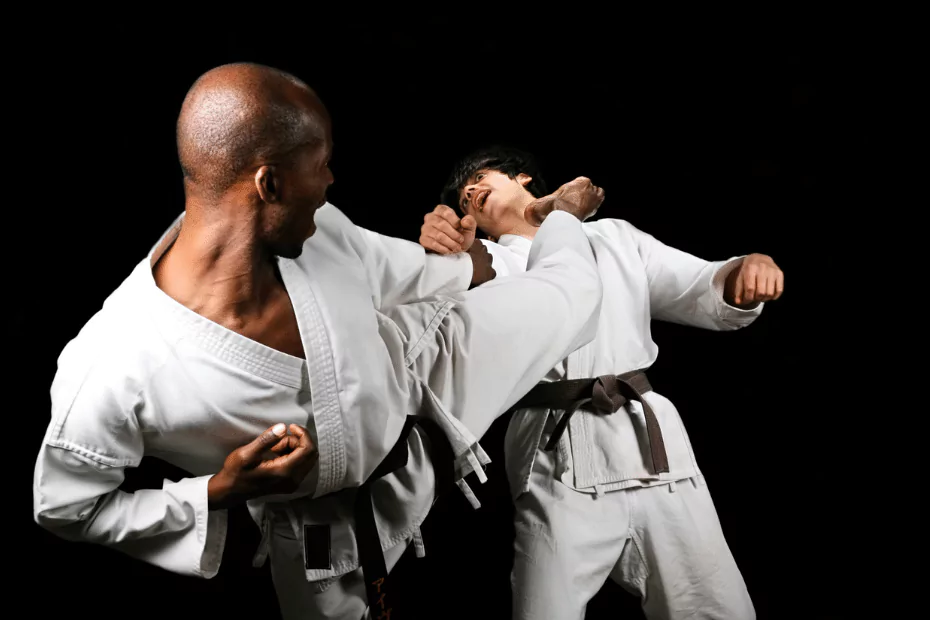 Two men engaging in karate practice on a black background.