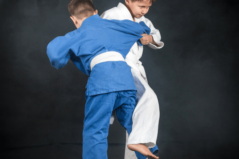 Two boys practicing karate and judo on a black background