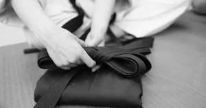 black and white photo, person tying belt and robe