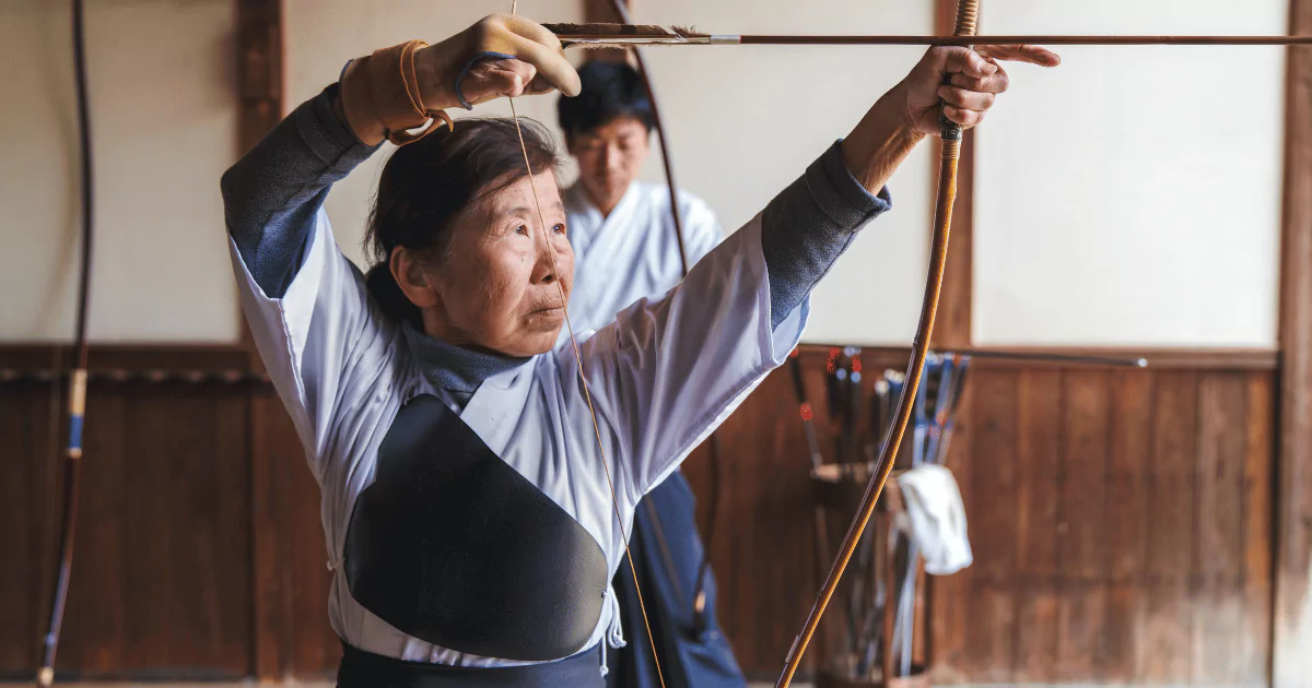 A woman mastering Kyudo with a bow and arrow