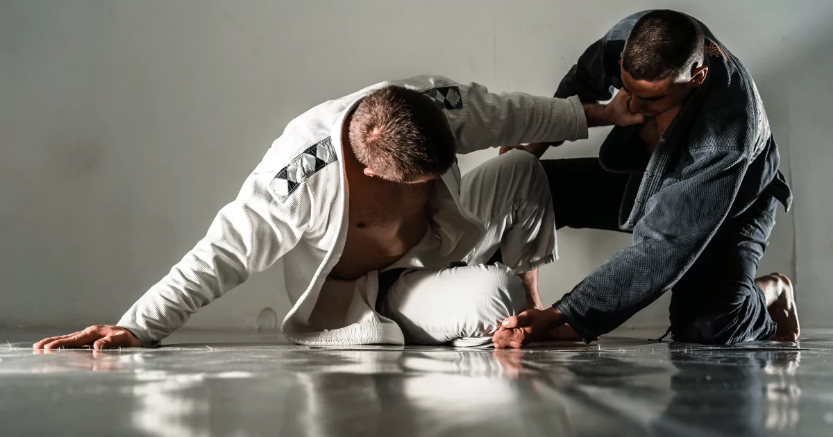 Two men mastering the basics of Brazilian Jiu Jitsu in a gym