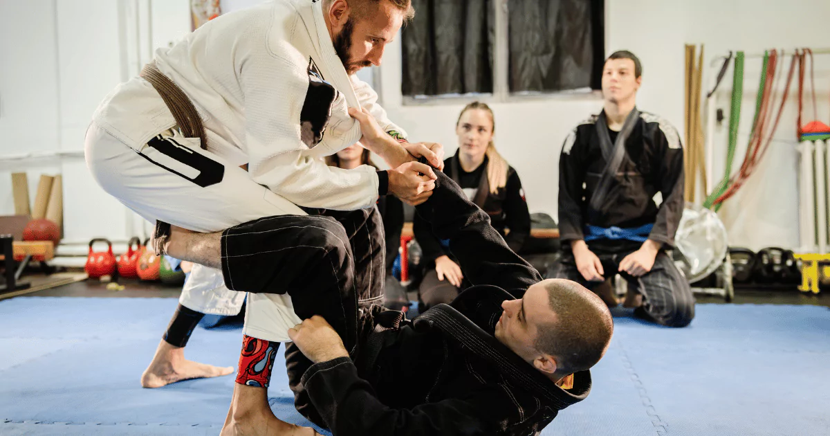 A man is mastering jiu jitsu moves in a beginner's class