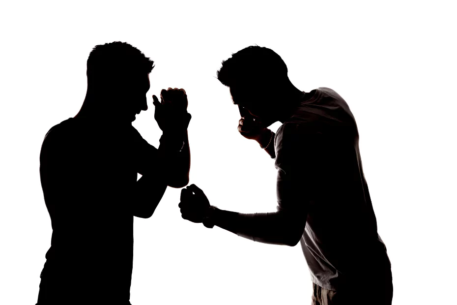 Two men in a silhouette engaged in boxing on a white background