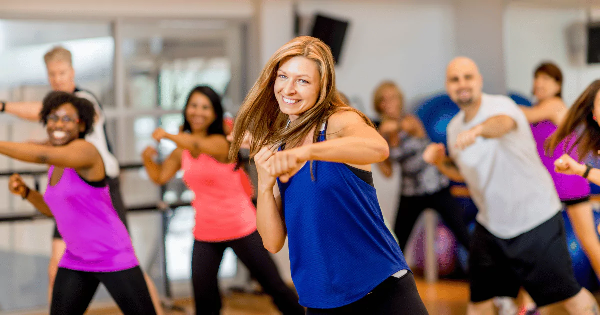 a group of people exercising, punching air, fitness class