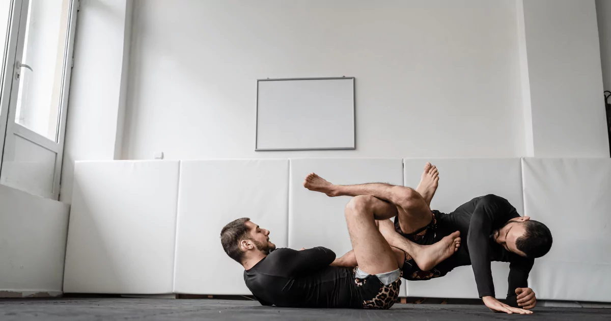 Beginner's Guide: Two men mastering jiu jitsu moves in a gym