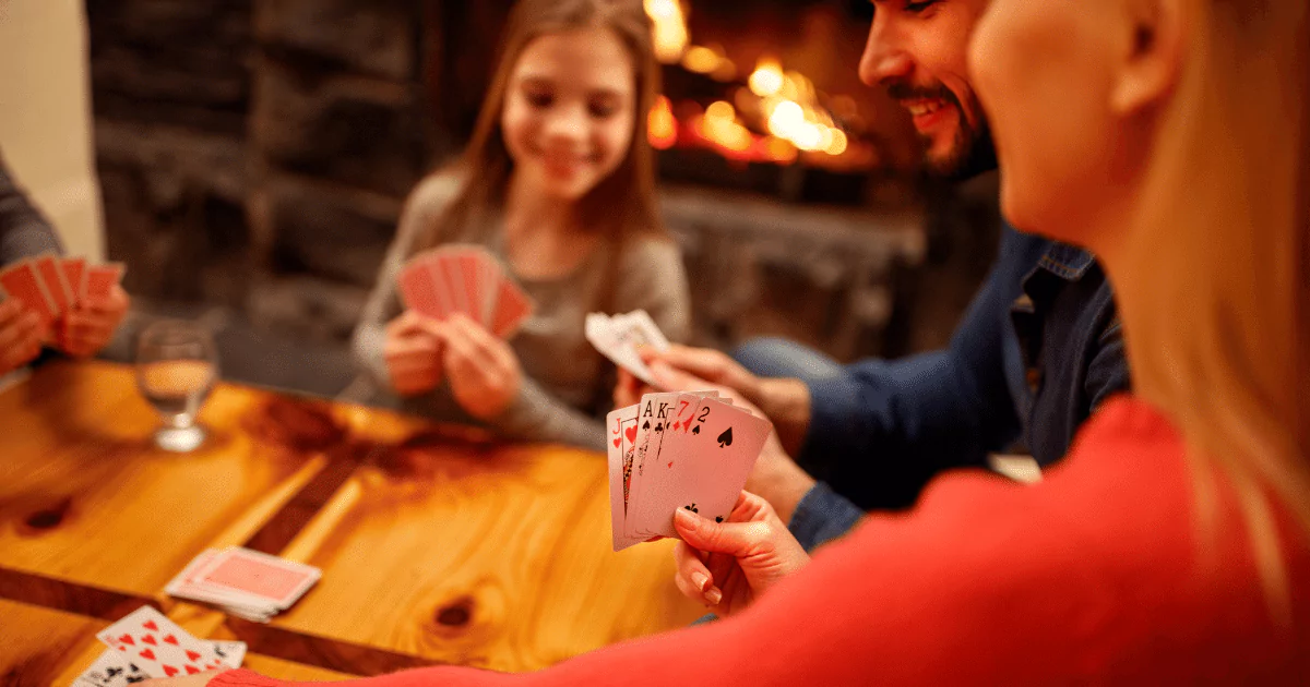 family playing a card game at a kitchen table